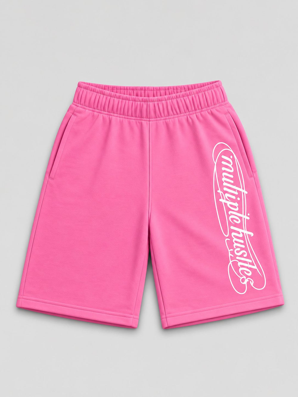 Multiple Hustles shorts in pink, front, with the looped script down the right leg