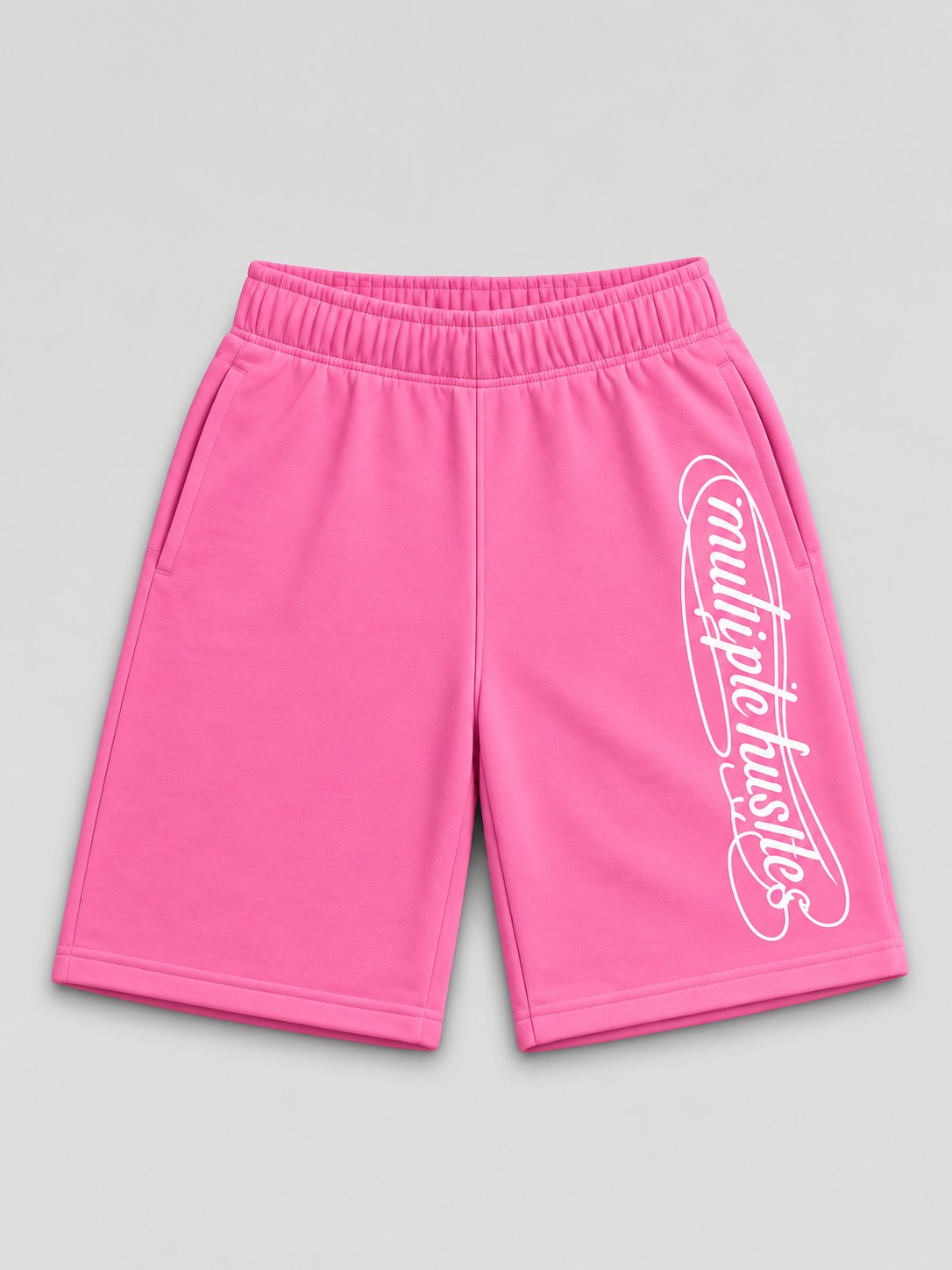 Multiple Hustles shorts in pink, front, with the looped script down the right leg